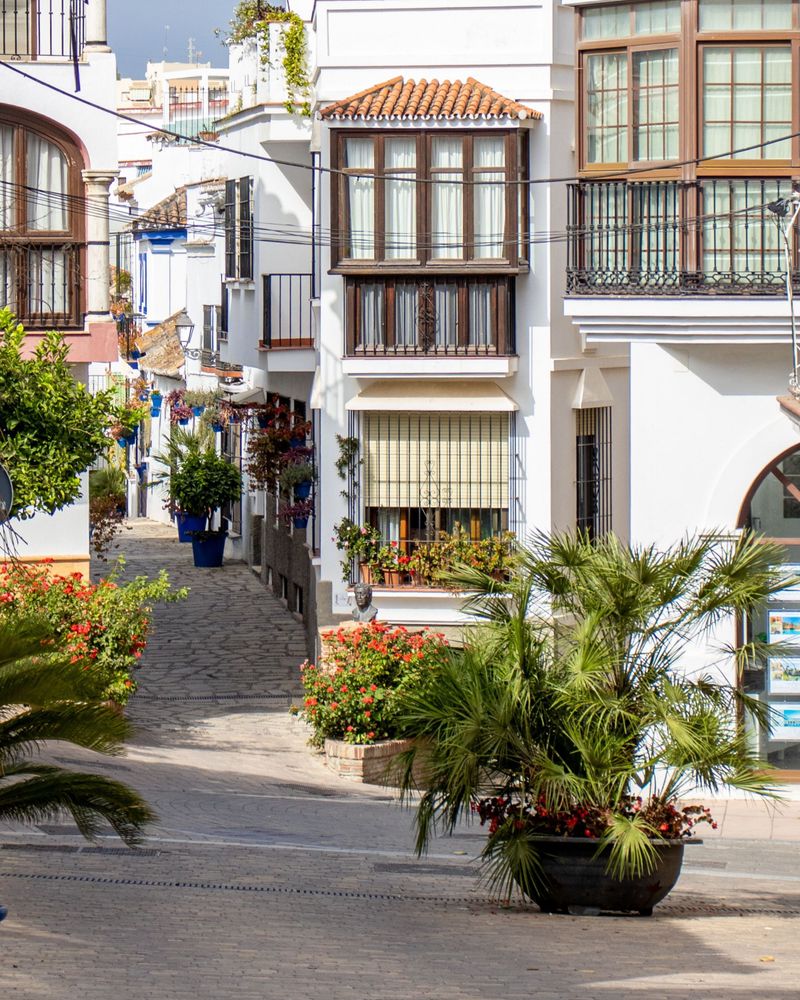 Whitewashed Andalusian street in Estepona old town with bougainvillea and balconies